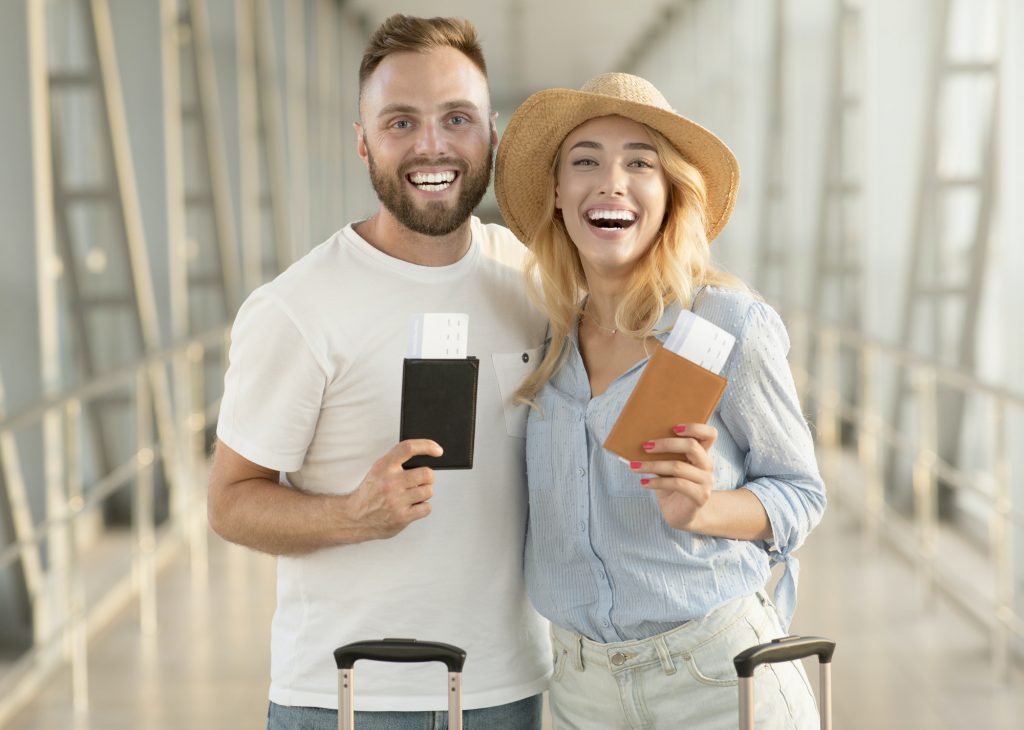 Happy couple with passports and tickets at airport terminal